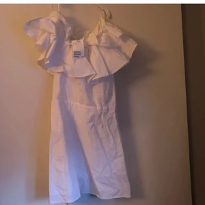 Vit volang klänning - Världens sötaste klänning med lappar kvar fårn hm stl 32 har ett litet hål vid dragkjedejan, går enkelt att sy ihop!! fraktas spårbar för 51kr och 36kr frimärken!❤️