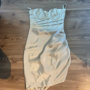 Fodralklänning  - Champagnefärgad klänning från H&M Exklusive. Aldrig använd i storlek 36