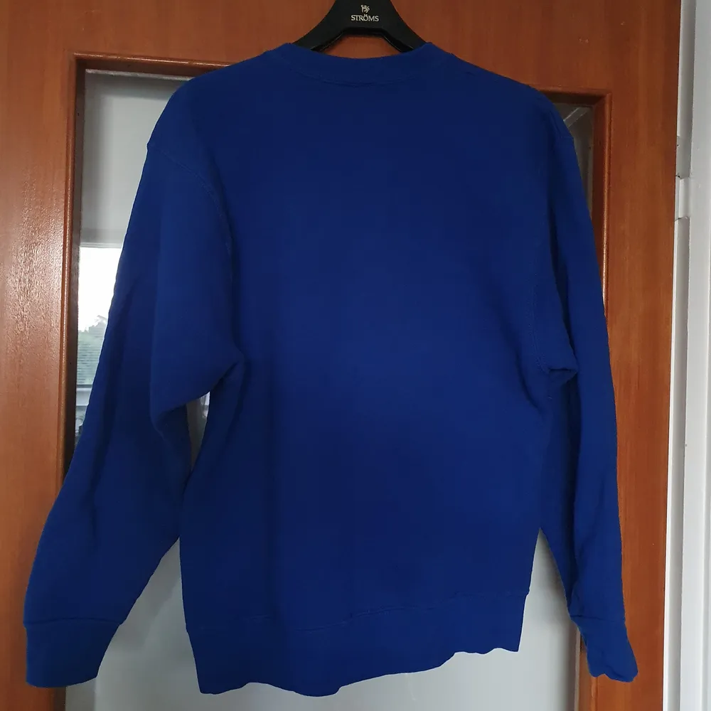 Klarblå sweatshirt köpt på beyond retro! Nött/skavd i trycket men fint begagnat skick i övrigt.. Tröjor & Koftor.