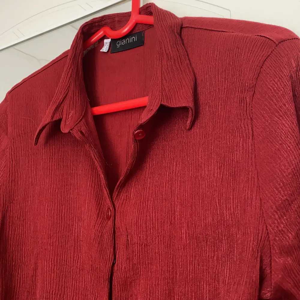 Jag säljer denna mörkröda vintage-blus köpt på second hand! Den har ett stretchigt material som gör att den passar olika kroppsformer. . Blusar.