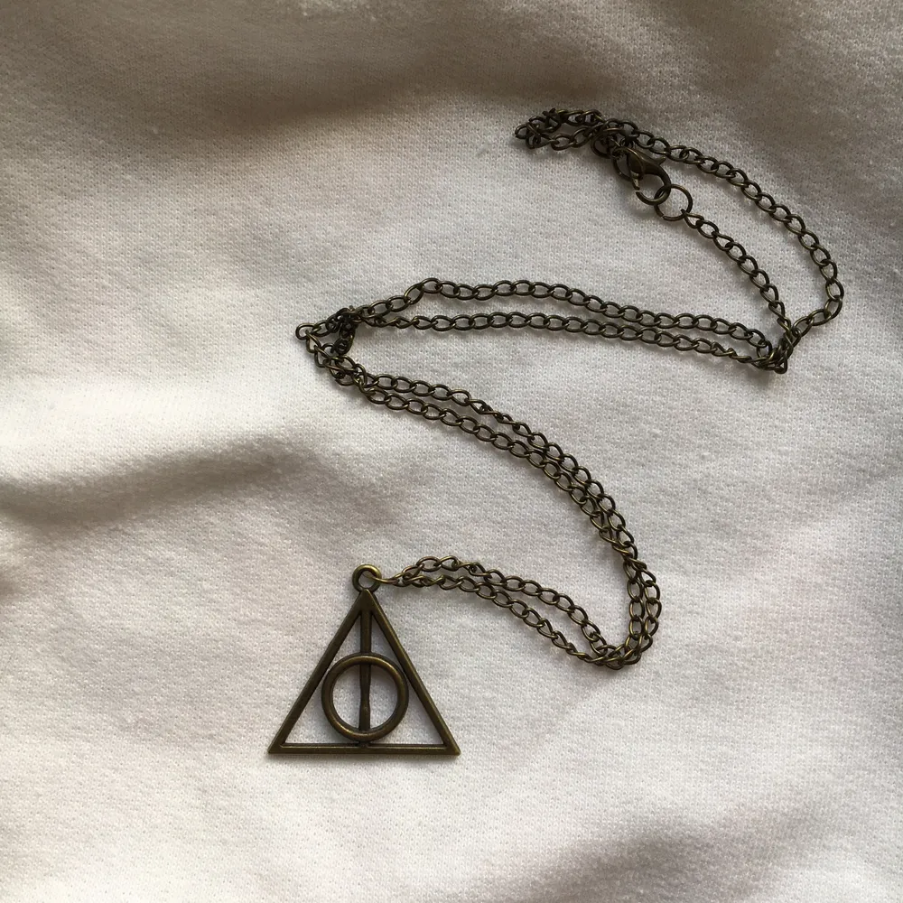 Halsband med deathly hallows från Harry Potter. Berlocken är ca 3cm. Kanppt använd . Accessoarer.