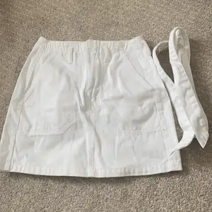 Vit denim kjol från bikbok, kommer med en bälte. Bra kondition, har inte används mycket men har en liten fläck på baksidan. Finns en dragkedja. Har fickor ❤️