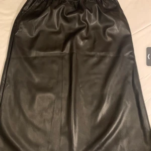 Lång skinnkjol 50kr - En lång skinnkjol för 50kr ny