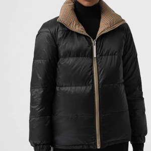 Burberry Dunjacka Vändbar - Dunjacka från Burberry. Jackan är vändbar och kan användas som svart eller klassiskt rutmönster. Jackan är i storlek M men passar även S. Väldigt gott skick, använd max 10ggr.
