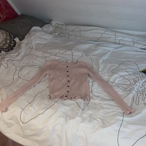 H&m - Säljer denna fina tröjan rosa tröjan från h&m den är i super super bra sick och har lite små volanger på tröjan och fina knappar   