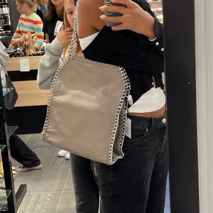 Tiamo väska - Super snygg Tiamo väska i grå(ljuset på första bilden gör så att den ser mer beige ut en grå)💗 inte använt så många gånger så väldigt bra skick. Perfekt för skolan då den rymmer massor av grejer. köpte för 550kr( Skriver för fler bilder)🥰