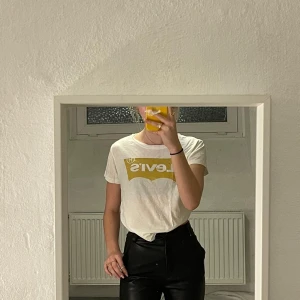 Levi’s T-shirt  - Vit levi’s T-shirt med guldigt tryck, storlek M med ganska liten i storleken 