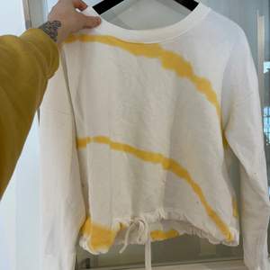 En vit och gul tröja ifrån only med snörning som man kan dra åt som man vill. Använd sparsamt.