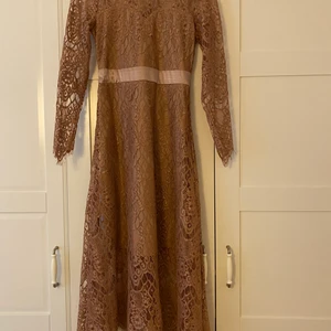 Rosa Festklänning  - Fin klänning i mycket gott skick, använd endast 1 gång på ett bröllop. Den är mer rosa än vad som framkommer av bilden. Rosetten bak går att ta av. Den är fäst med en liten tryckknapp. 