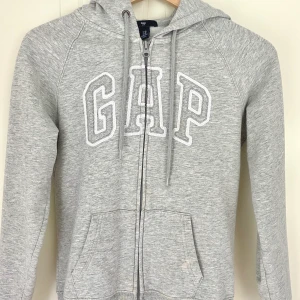 Gap zip up hoodie - Superfin grå zipup GAP-hoodie <3 Det finns några fläckar längst ner på tröjan som ej går bort i tvätten (se sista bilden), men det syns knappt när den sitter på 💛 frakt tillkommer!
