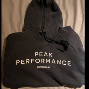 Peak Performance Hoodie - Säljer min väl använda Peak Hoodie då den inte kommer till användning längre. Jättebra skick och inga defekter. Mörkblå/svart ish färg och i strl M. Sitter oversized på mig som brukar ha S. Frakten är inräknad i priset
