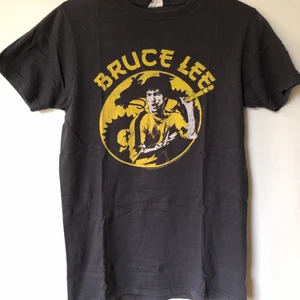Retro Bruce Lee Game Of Death Tee - Retro Bruce Lee Game Of Death T-Shirt Size small, fits like a regular men’s size small.  Excellent condition, no flaws or damage.  DM if you need exact size measurements.   Buyer pays for all shipping costs. All items sent with tracking number.   No swaps, no trades, no offers. 