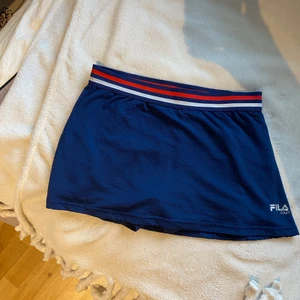 Fila court tenniskjol - Tenniskjol från fila i storlek S men är ganska liten i storleken så XS till S. Jag är 173 cm och den är väldigt kort på mig 😅 Kjolen har underbyxor där man kan lägga upp till två tennisbollar 🎾 😊 ( köpare betalar också frakt) 