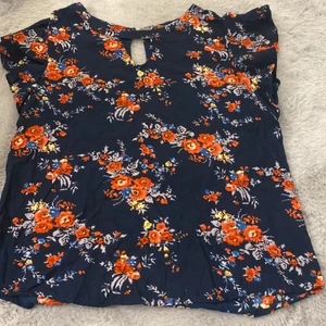 Blommig blus. MissMilla, köpt på Ullared - En jättefin blommig blus med volanger på axlarna. Mörkblå ”bakgrund”. Stl S eller 36