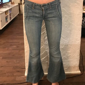 Lågmidjade Levis jeans - Lågmidjade Levis jeans. Ganska tunna i materialet. Ena sån skärphaken är sönder (bild 2) och de är igen sydda i baken (inget man märker)  men annars i bra skick. De var tyvärr för korta för mig som är typ 172cm. Innerbensmåttet: ca 70cm midjemåttet: ca 35cm rätt över. 