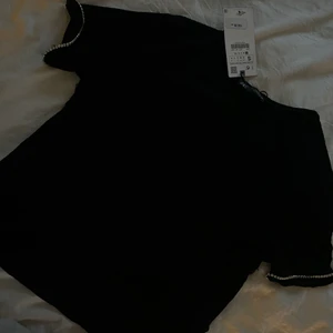 stickad t-shirt - fin svart stickad t-shirt, helt ny med prislapp stl S men passar också xs, fina paljett detaljer på ärmarna<33