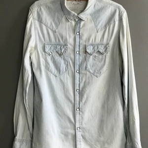 Levi Strauss & Co Jeans Jacka/skjorta - En mycket fin ljusblå jeansjacka i storlek large.  Märke: Levi Strauss & Co /Levi’s Typ: Jeansjacka skjorta Storlek: L Färg: Blå ljusblå Material: Bomull Tyg: Denim   Kan hämtas i Enskededalen/Blåsut eller skickas