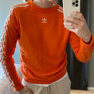 Orange adidas original tröja. Stripade armar och logga mitt på bröstet. Fint skick.