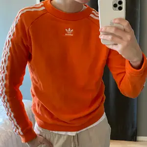 Orange adidas original tröja. Stripade armar och logga mitt på bröstet. Fint skick.