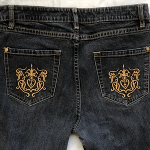 jeans med broderi - Gråa victoria beckham liknande jeans men guldiga broderade mönster på bakfickorna. Raka ben och midwaist. Midjemått: 80cm. Säljer då de inte passar mig:( Köparen står för frakten❣️