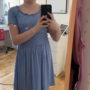 En blå blommig klänning  - En fin blå klänning, aldrig använd