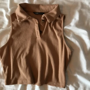 Croptop från Shein - Beige ribbad croptop med krage från Shein                     Aldrig använd.                                                       Storlek: 36                                                                 Nypris: 79kr