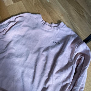 Sweatshirt - Rosa sweatshirt med detalj på bröstet. 