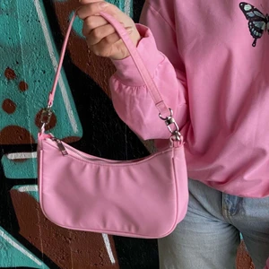 Rosa väska - Säljer en exakt likadan väska som bild 1 då jag råkade beställa två likadana. 🤪 Väskan som säljes är helt oanvänd och är i oöppnad förpackning. Väskan är köpt på Bikbok för 250kr, mitt pris är 100kr! 💗💗