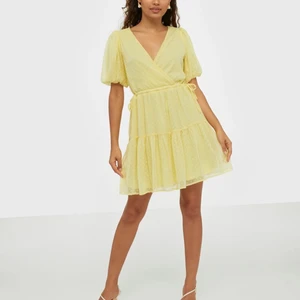 NLY Trend klänning i strl 44 - Gul klänning från Nelly i superfin färg! Dessutom ett superfint mönster på den! Den är lite för stor för mig vilket är väldigt tråkigt eftersom jag tycker den är så fin! Puffarmar, volang ner till och bälte i midjan för att kunna göra den tightare eller lösare. Nypris 499kr🤎 köparen står för frakten!