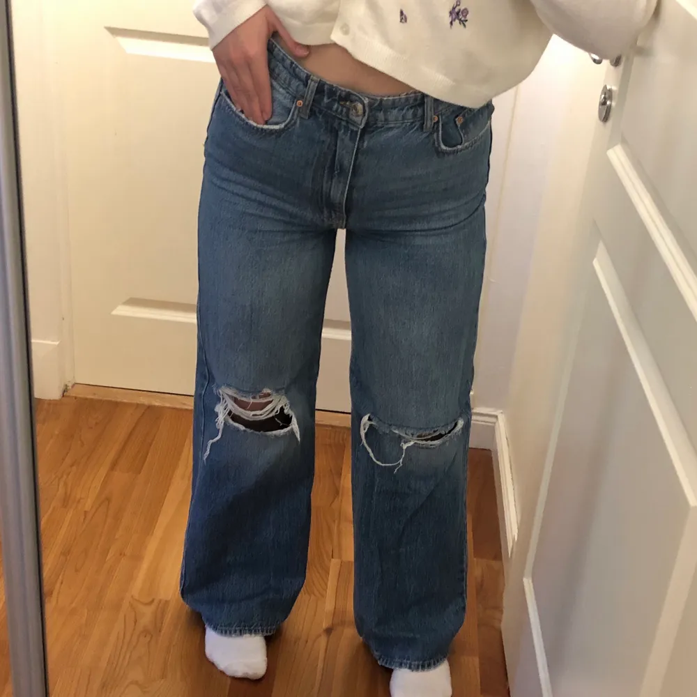 Ett par mörkblåa jeans med knä-slitning. De går ut lite mer där nere men inte bootcut. Ganska långa, själv är jag 173 cm lång. I bra skick. . Jeans & Byxor.