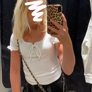Vit topp - Väldigt fin topp med snörning upptill. Den är i fint skick. Köpt på H&M. 