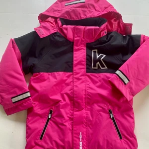 Kaxs barnjacka. - Vindtät och vattenavvisande fodrad cerise vinterjacka.