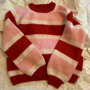 Rosa röd randig stickad tröja - En superfin och mysig stickad tröja! Lite små nopprig men annars väldigt snygg. Den är väldigt mjuk och sticks inte! Köparen står för frakten💕😀 Hör av er för fler bilder! 