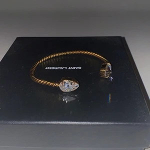 Caroline Svedbom armband - Detta armband fick jag för ungefär 3 årsedan, väldigt gott skick, inga repor eller skador eller missfärgning. Guldigt med en vit sten. Nypris 599 kr. 