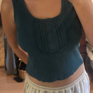 Blå tank topp - Så fin blå tröja med så snygg detalj vi kragen! Har själv klippt av den till en perfekt magtröje längd. Den är ribbad och snäppet ljusare i verkligheten!