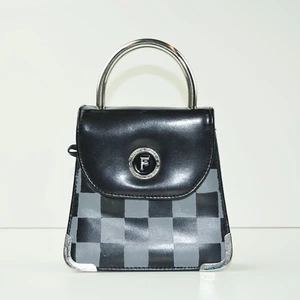 Check✨ by M.E.J UF - En liten svart väska utan axelband. Väskan har gråa rutor på framsidan med silvriga detaljer.  