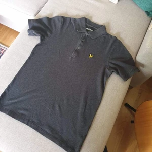 Lyle & Scott Piké t-shirt storlek S - Mörkgrå Lyle & Scott piké i bra skick. Dessa går aldrig ur stil och passar året om. Funkar till vardagen, finare sammanhang och även fester.