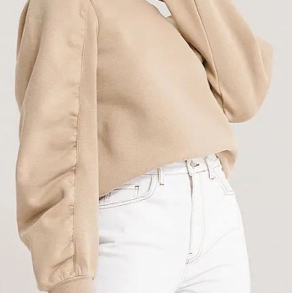 Sweatshirt från NA-KD, beige med lite ballongärm, rå kant nertill och vid i modellen, supersnygg! Knappt använd. Strl xs. . Tröjor & Koftor.