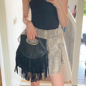 Frans väska - Super cool väska med fransar som kan bäras med band eller i handen. Bandet är avtagbart.