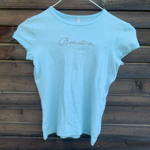 Baby tee - Ljusblå baby tee💙 Tröjan är knabbt använd och det står benetton i silvrigt glitter ✨ tröjan passar både S och XS