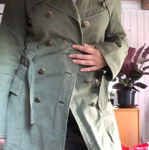 Grön kappa - Vintage Grön kappa med fina detaljer och knappar. I midjan finns det ett skärp i samma gröna färg. Finns knappar att stänga jackan med också.🌱