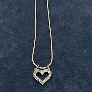 Handgjord hjärta halsband i guld.  Hjärtat är designat med horn. Halsbandsbandet är gjort så att hjärtat inte ramlar av.