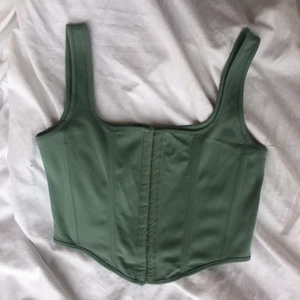 Korsett - Underbar grön korsett. Märkt som storlek m men sitter bra på mig som bär s. Gott skick utan några defekter. Köpare står för frakt. Även väskan på sista bilden säljs! Högsta bud 200kr. Köp direkt för 300kr