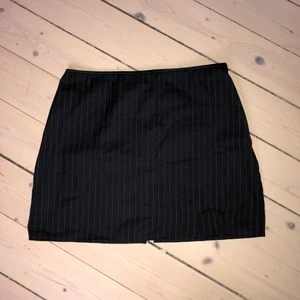 Pinstripe-randig kjol - Svart och vit pinstripe-randig kjol men slits på ena låret. Kort och mid/lowwaist. Köpt på humana för 1,5 år sen. Köparen står för frakten 💓