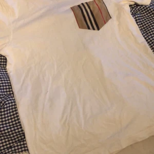 Burberry t shirt junior - Inga defekter eller liknanade förutom vid fickan på framsidan av tröjan där det är någon liten missfärgning. Storlek 14-16. Nypris 2,500kr köpt på Nordiska kompaniet i Stockholm. Mitt pris 400kr därefter fläcken på tröjan. 