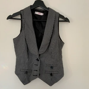 kostymväst  - Rutig kostymväst med svart rygg. Den är i bra skick och ett plagg som passar till mycket. Säljer till högst budande😊