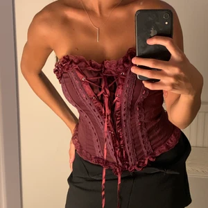 Korsett  - Vinröd korsett i S. Går att justera