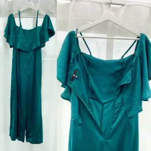 Vacker off-shoulder jumpsuit i satin. Långa ben och dragkedja i ryggen. Färgen är emerald/mörkgrön och svår att få bra bild på. Bara använd 1 gång.   Strl 36. True to size.   Nypris: 450 kr Mitt pris: 200 kr