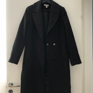 Vinterkappa  - Svart kappa från hm i rak modell. Sparsamt använd, mycket bra skick. Storlek 34. Finns ett skärp till (bild 2). Frakt tillkommer. Nypris: 799kr