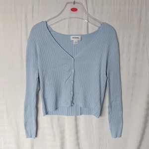 Ljusblå Monki cardigan - Ljusblå topp/cardigan från Monki 💙 Kan båda vara en topp eller cardigan beroende om man vill ha den knäppt eller inte, några knappar knäppta ser också fint ut. 😊 V-ringning. Toppen är ribbad och mycket stretchig, så passar även S och L. Aldrig använd ❣